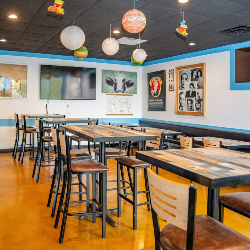 Reyes Mexican Grill's dining area with high-top tables, bar stools, and colorful decor.